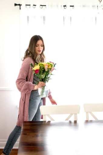 Woman adding flowers to her table to refresh home for spring.