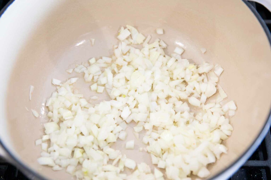 Onions being cooked in a dutch oven.