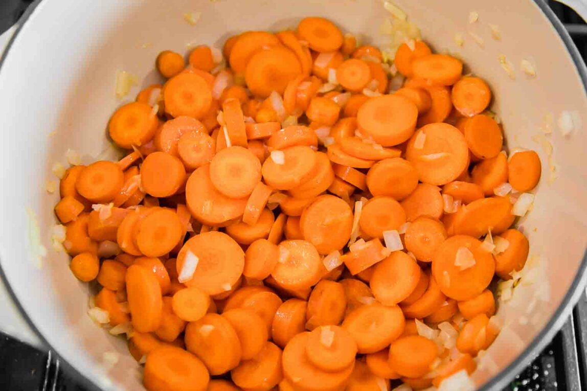 Carrots being cooked in a dutch oven.