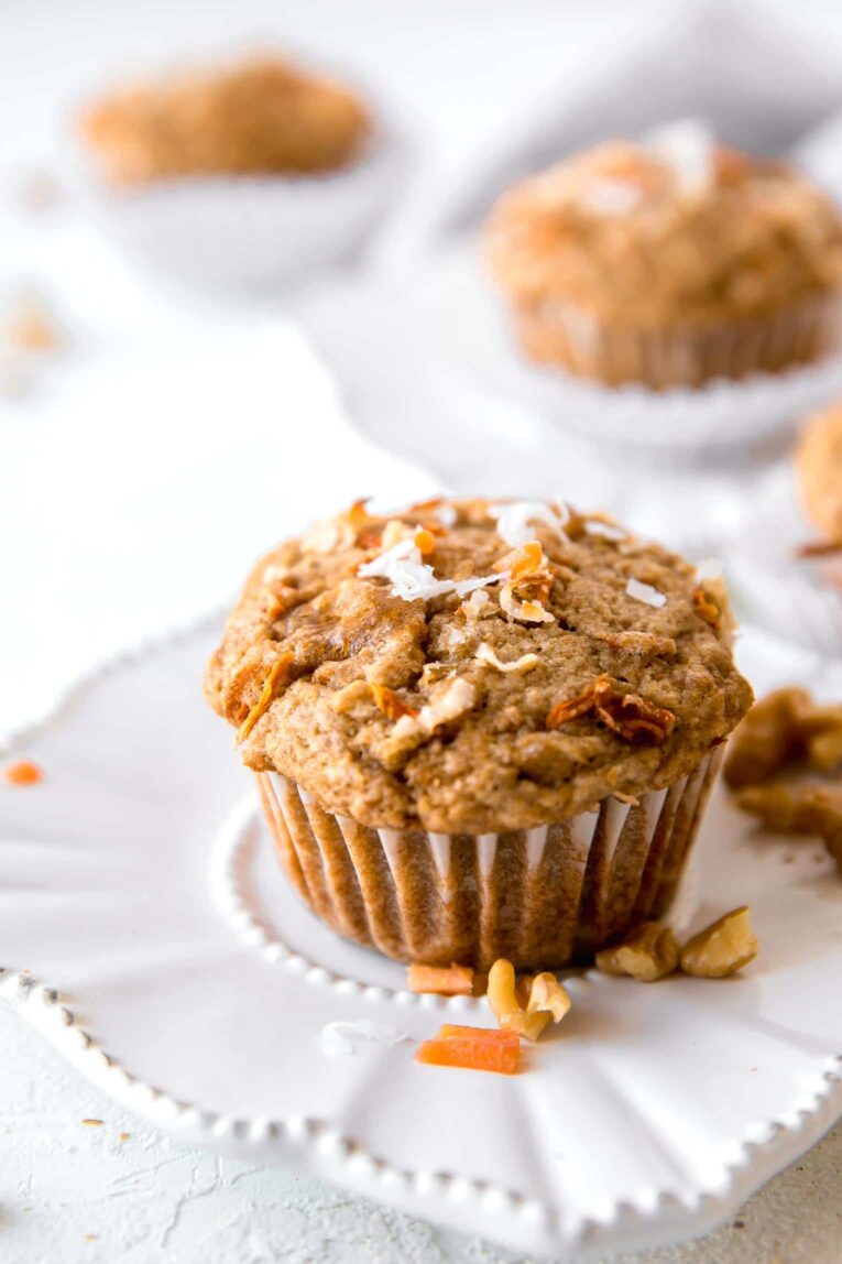 Angled shot of healthy carrot cake muffin on a white plate.