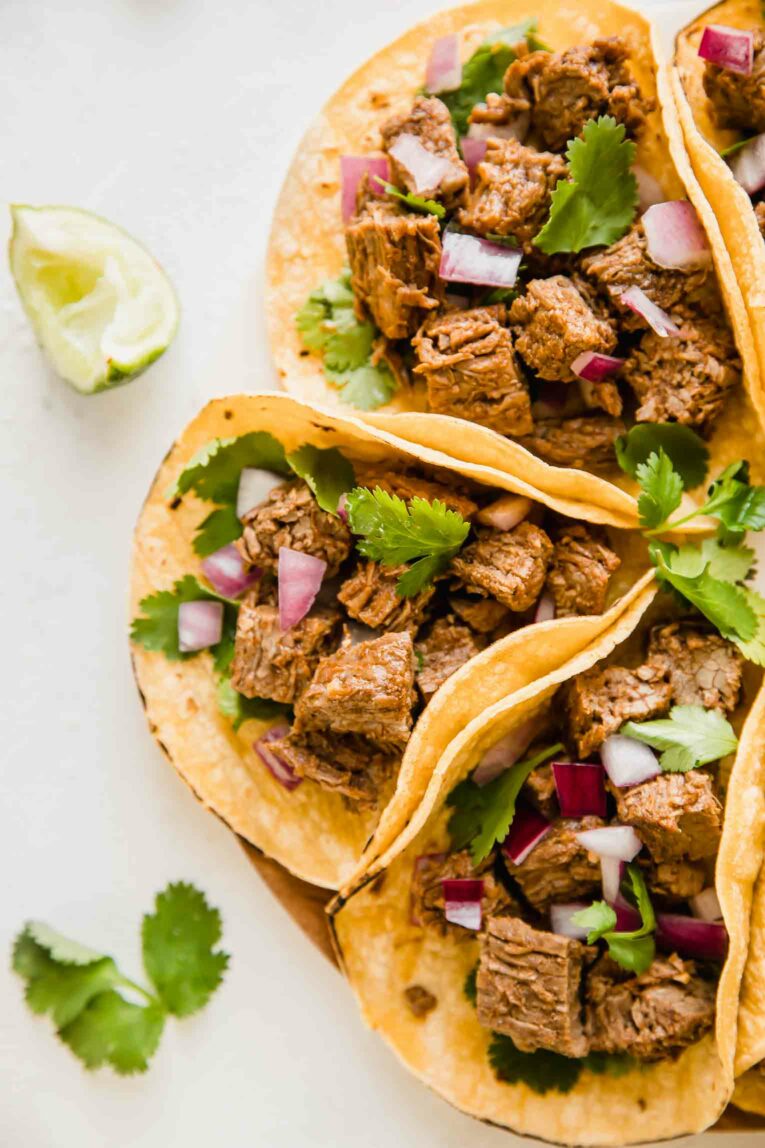 Instant Pot Carne Asada Tacos next to a sliced lime and cilantro.