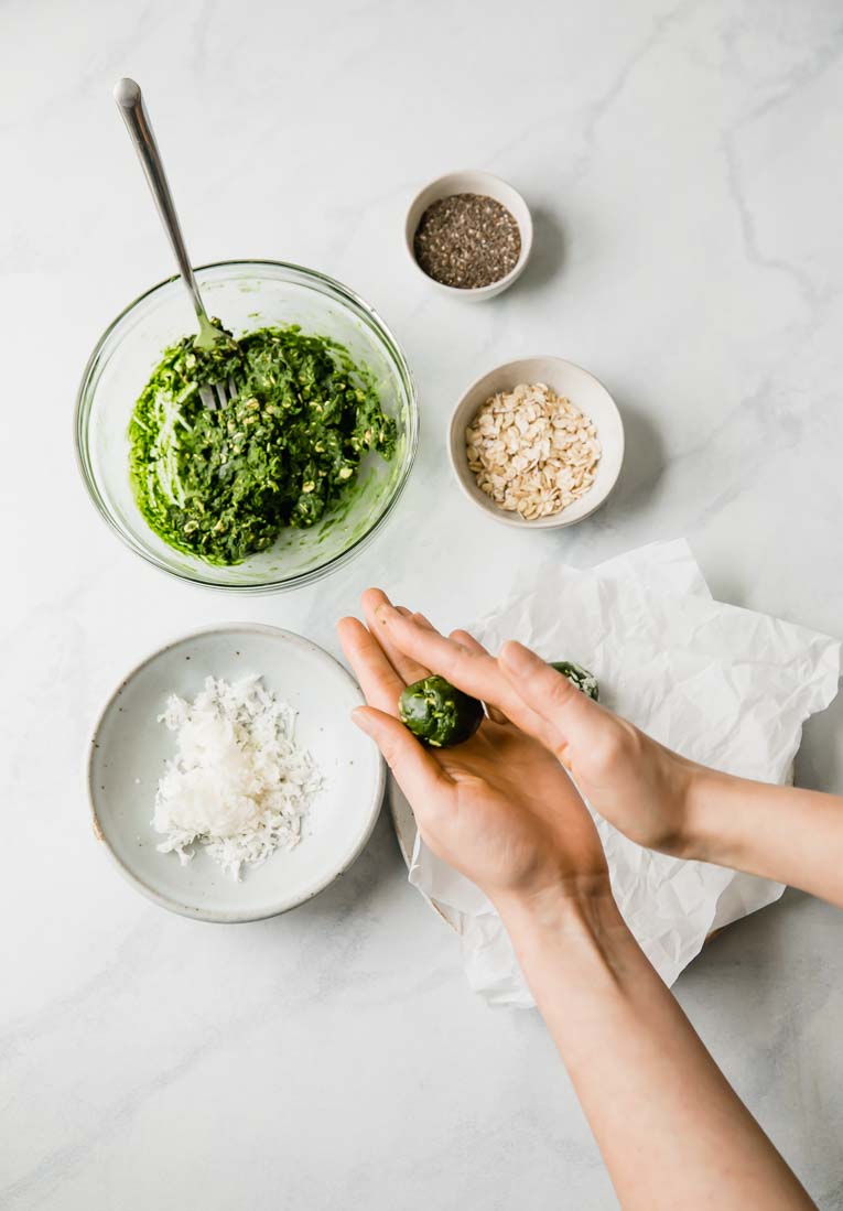 A hand rolling energy bites into balls.