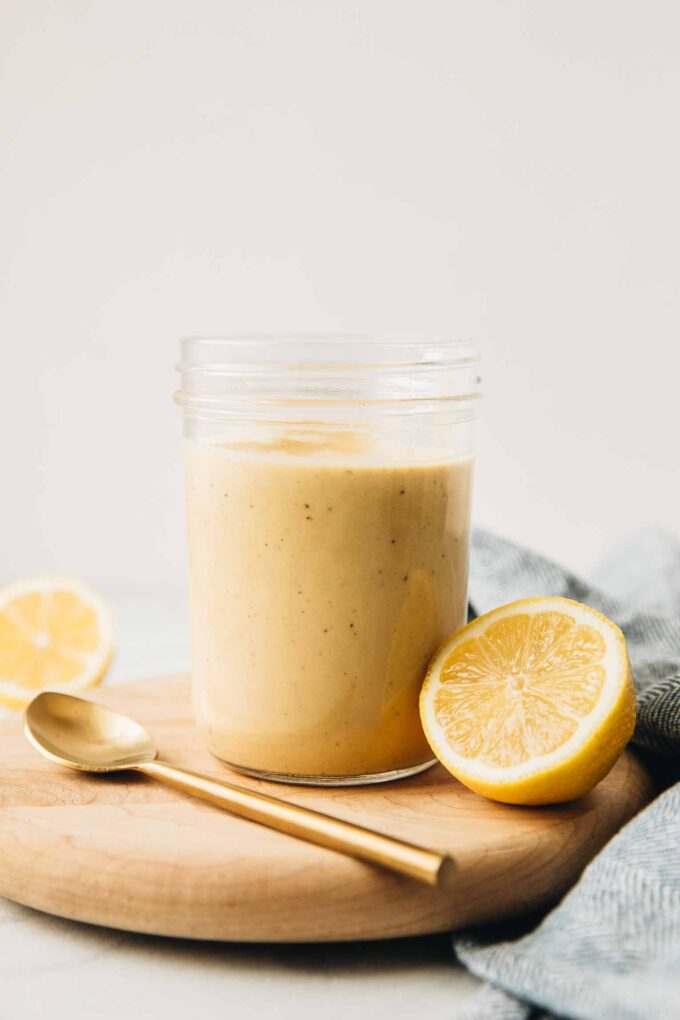 Close up of Creamy Lemon Tahini Dressing in a mason jar.