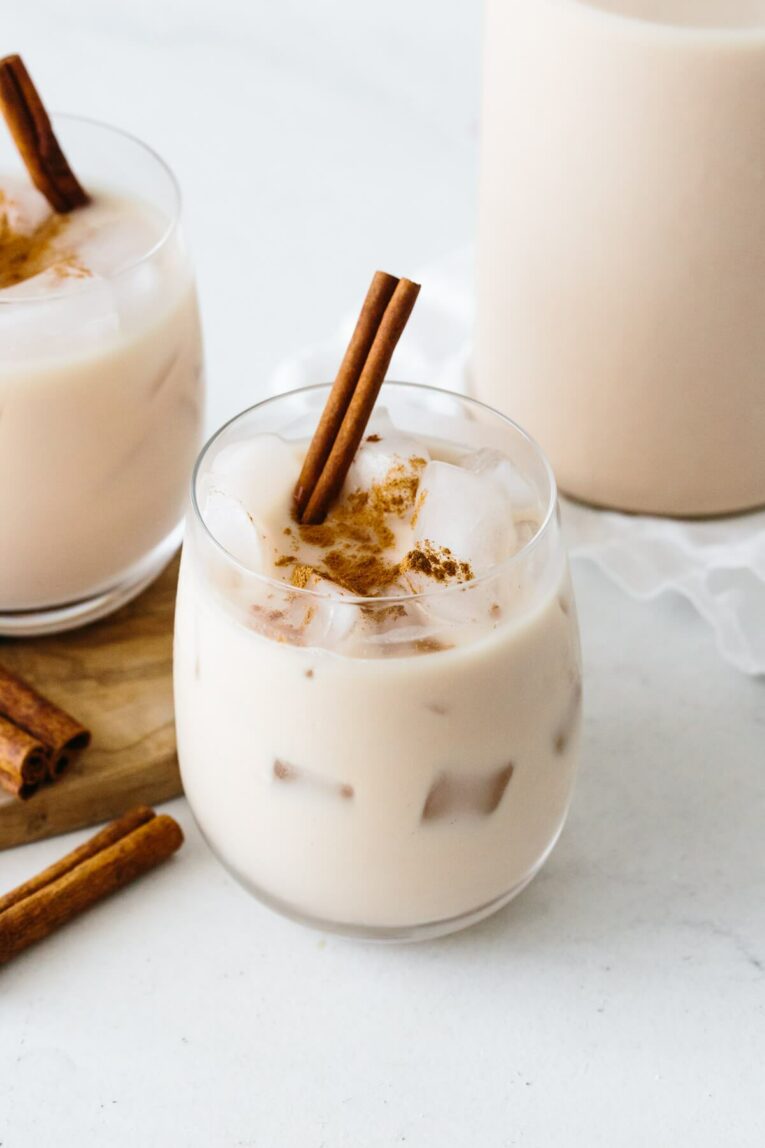 A photo of a glass filled with horchata drink and cinnamon.