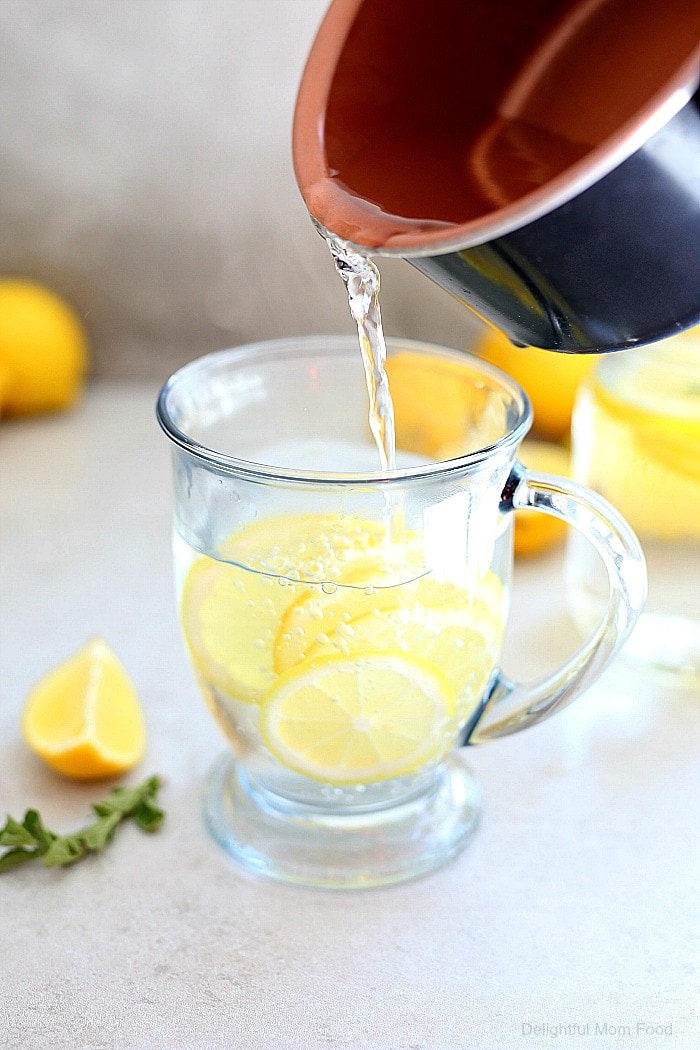 A clear glass mug with hot lemon water. 