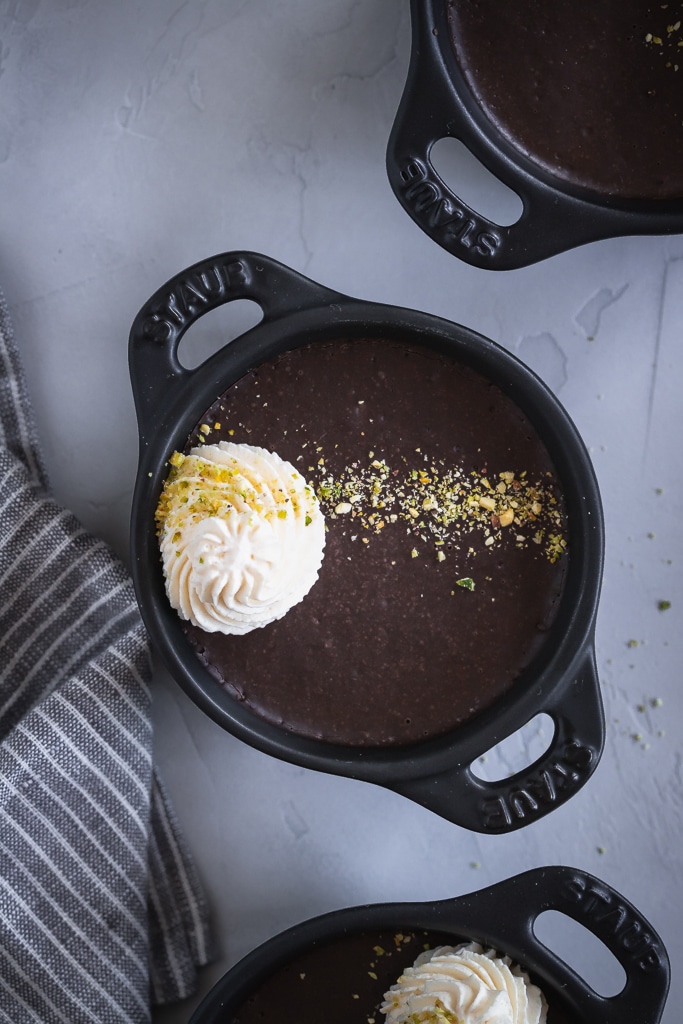 A top shot of a small ramekin with chocolate custard inside.