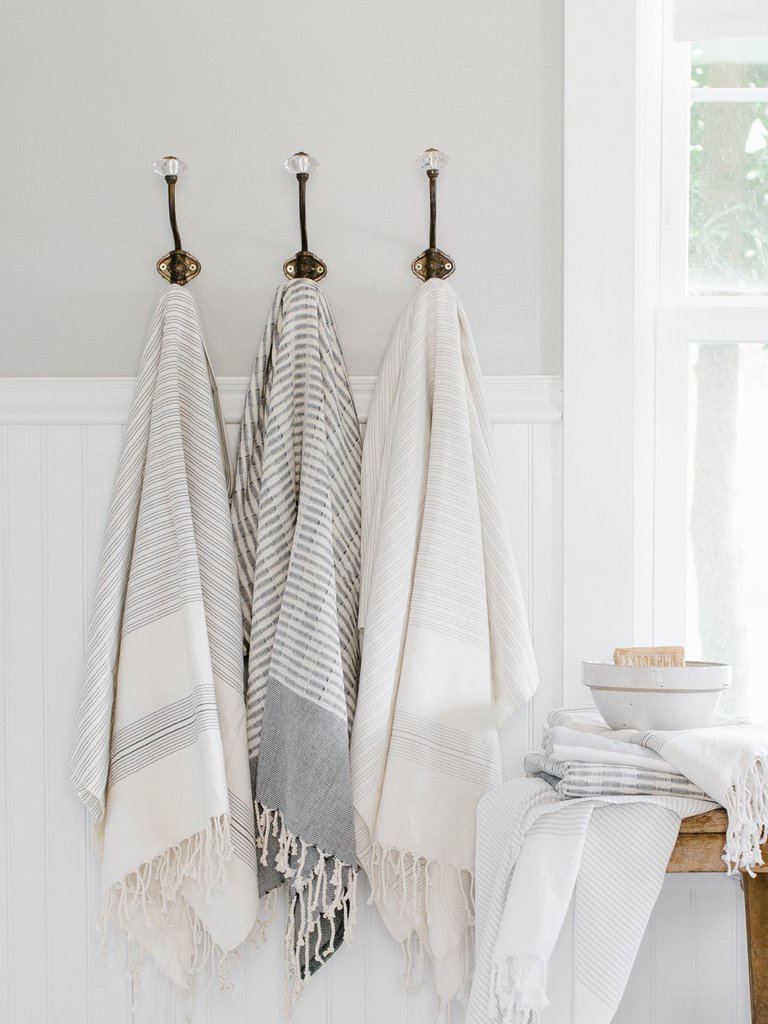 A group of 3 hooks with hanging towels.