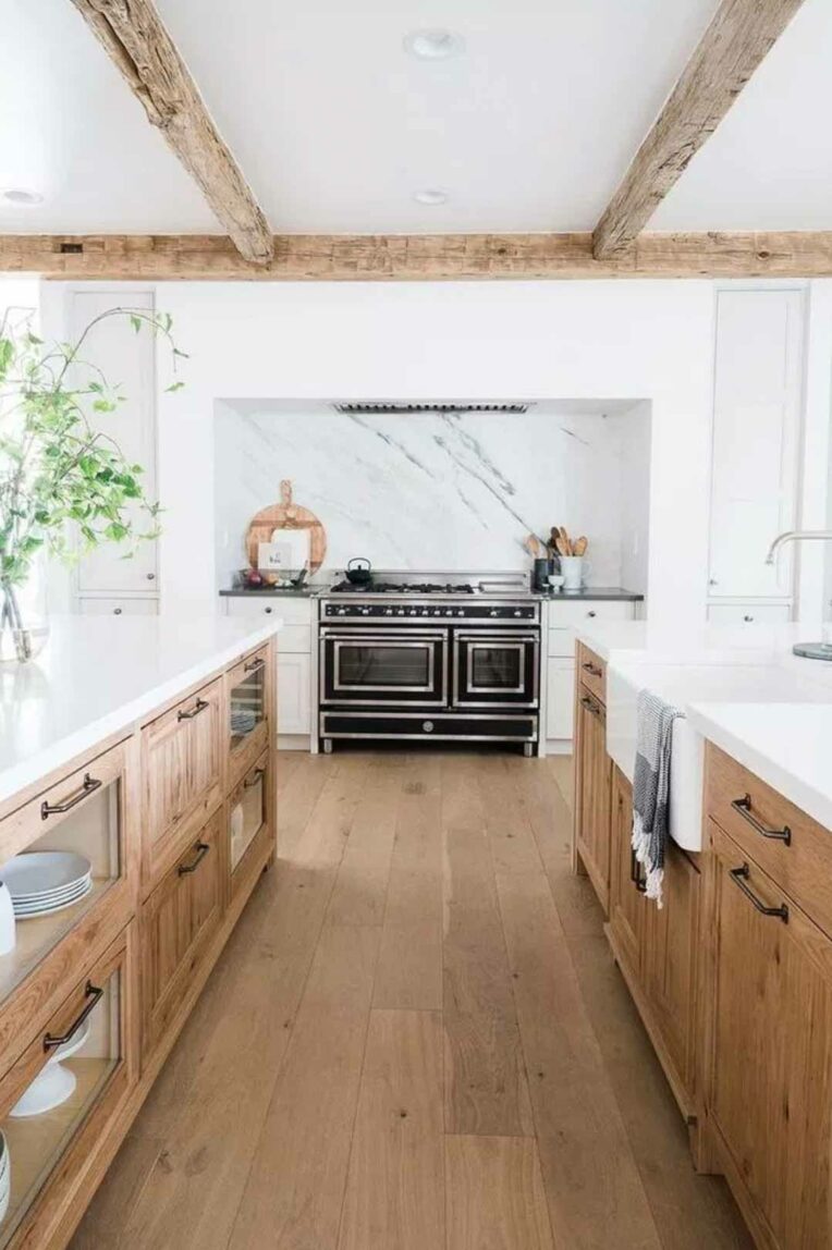 White kitchen with white countertops and natural wood cabinets.