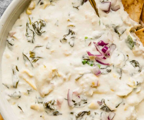 Close up of creamy spinach artichoke dip in a large bowl for a crowd.