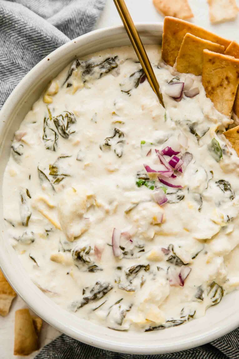 Close up of creamy spinach artichoke dip in a large bowl for a crowd.