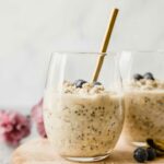 Vanilla Cream Protein Overnight Oats in a glass cup with a spoon.