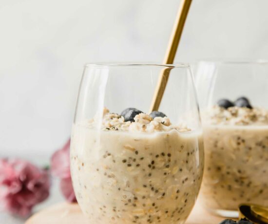 Vanilla Cream Protein Overnight Oats in a glass cup with a spoon.