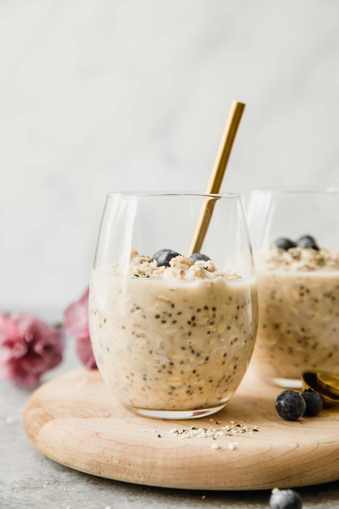 Vanilla Cream Protein Overnight Oats in a glass cup with a spoon.