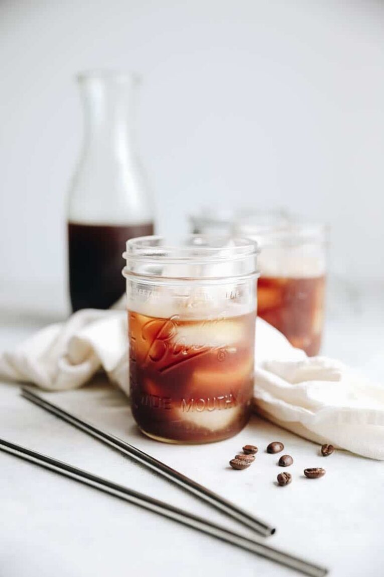 A mason jar with ice and cold brew coffee.