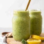 Across shot of Green Apple Detox Smoothie in a mason jar with a gold straw.