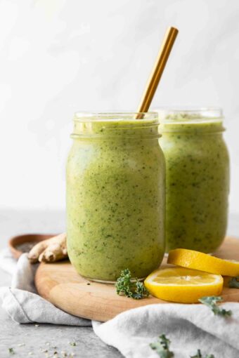 Across shot of Green Apple Detox Smoothie in a mason jar with a gold straw.