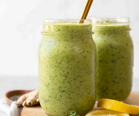Across shot of Green Apple Detox Smoothie in a mason jar with a gold straw.