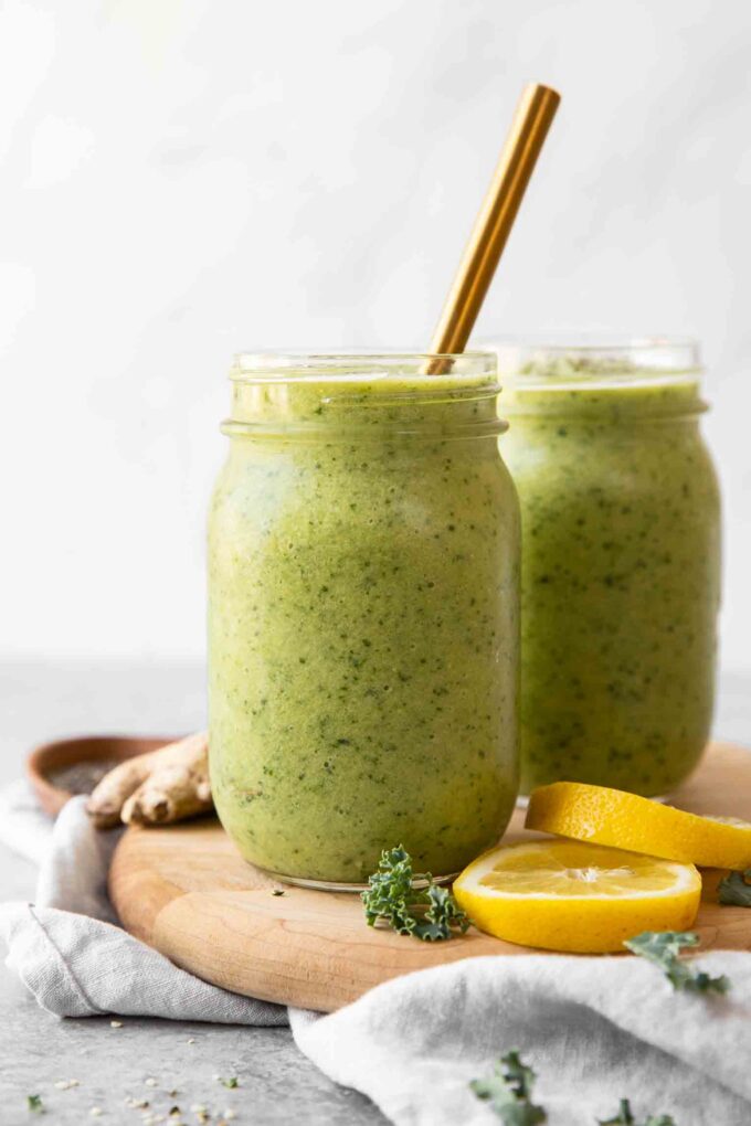 Across shot of Green Apple Detox Smoothie in a mason jar with a gold straw.