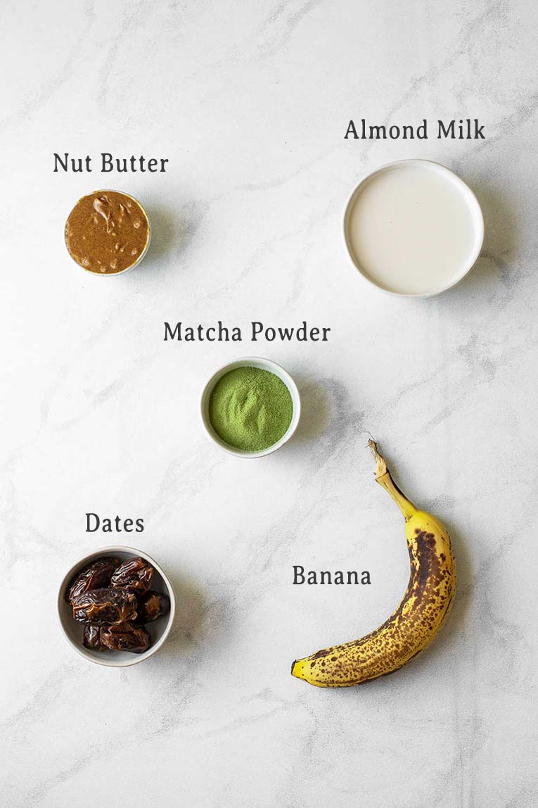 Ingredients for Matcha Banana Smoothie Bowls on a marble board.