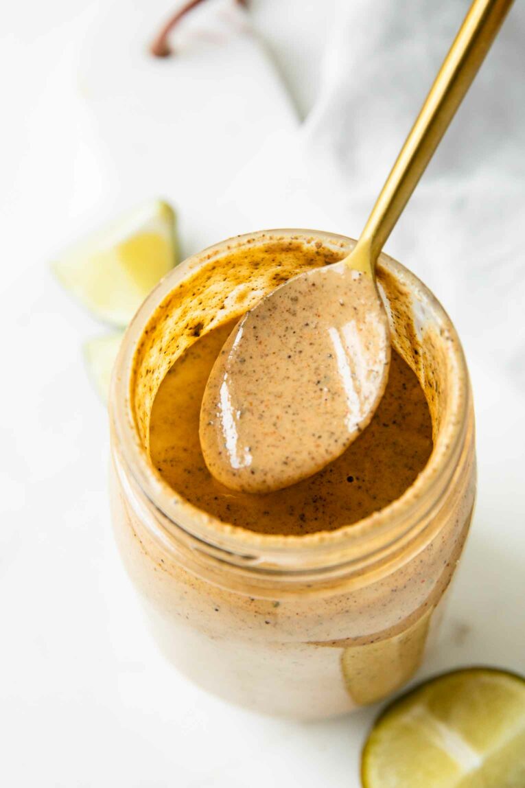 Spoon with southwest salad dressing in a mason jar.