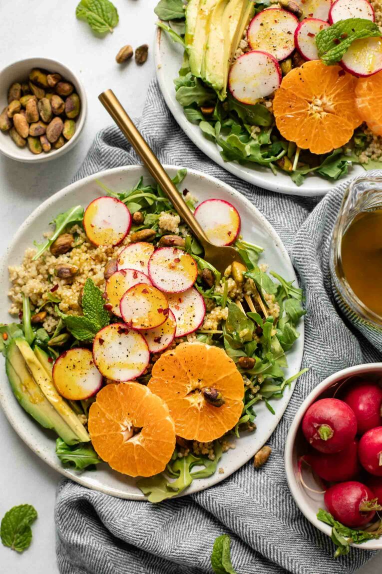 Arugula salad with spicy radishes, tangerines, summer quinoa, and avocado.