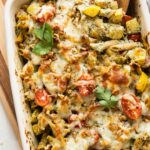 Top shot of Chicken Pesto Pasta Bake with a wooden spoon.