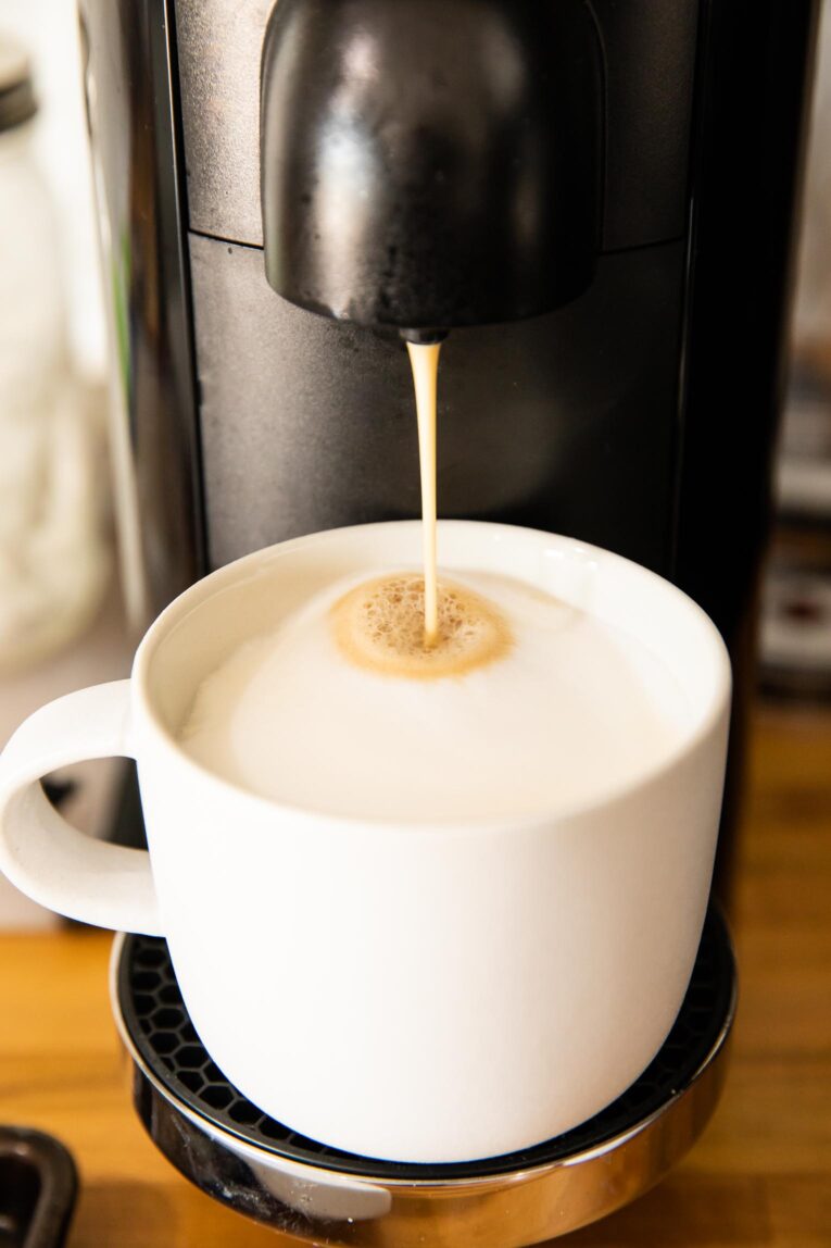 Nespresso machine making a coffee latte.