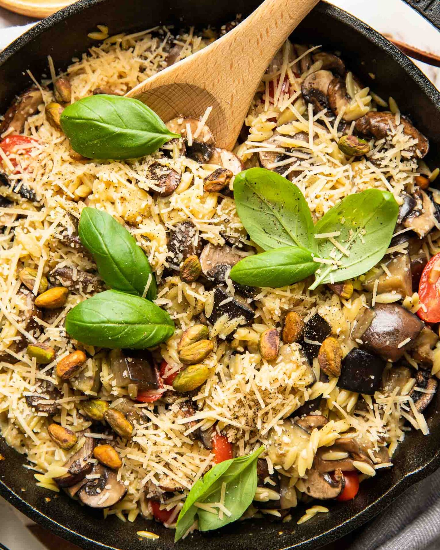 Lemon Garlic Eggplant Mushroom Orzo in a skillet with fresh basil.