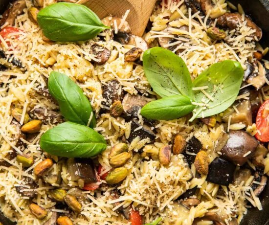 Lemon Garlic Eggplant Mushroom Orzo in a skillet with fresh basil.