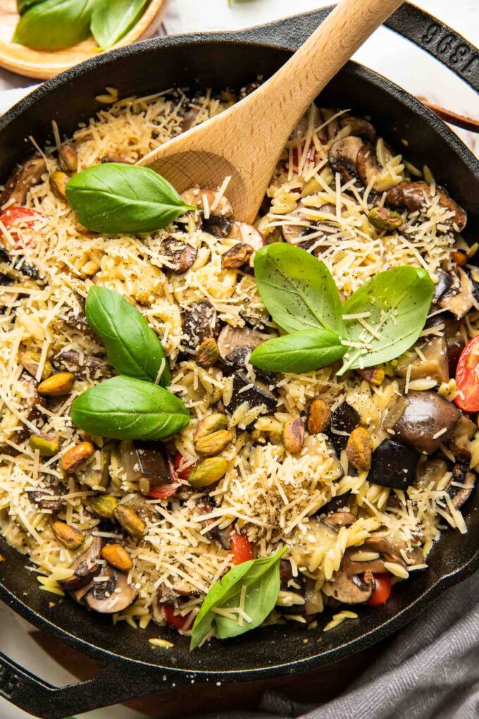 Lemon Garlic Eggplant Mushroom Orzo in a skillet with fresh basil.