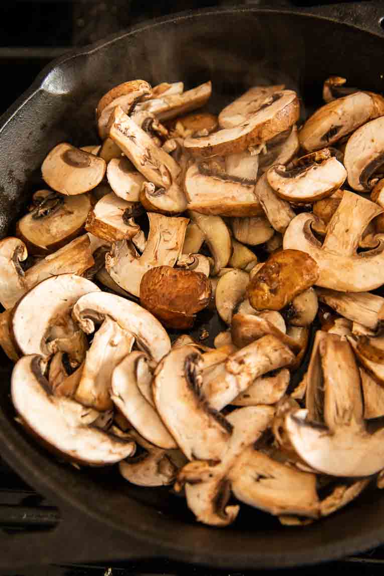 Mushrooms being cooked in a skillet.