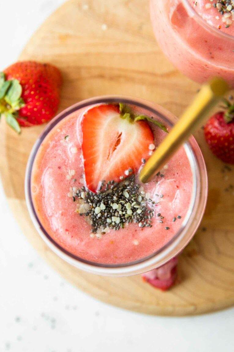 Top shot of Strawberry Pineapple Smoothie with toppings and a spoon.