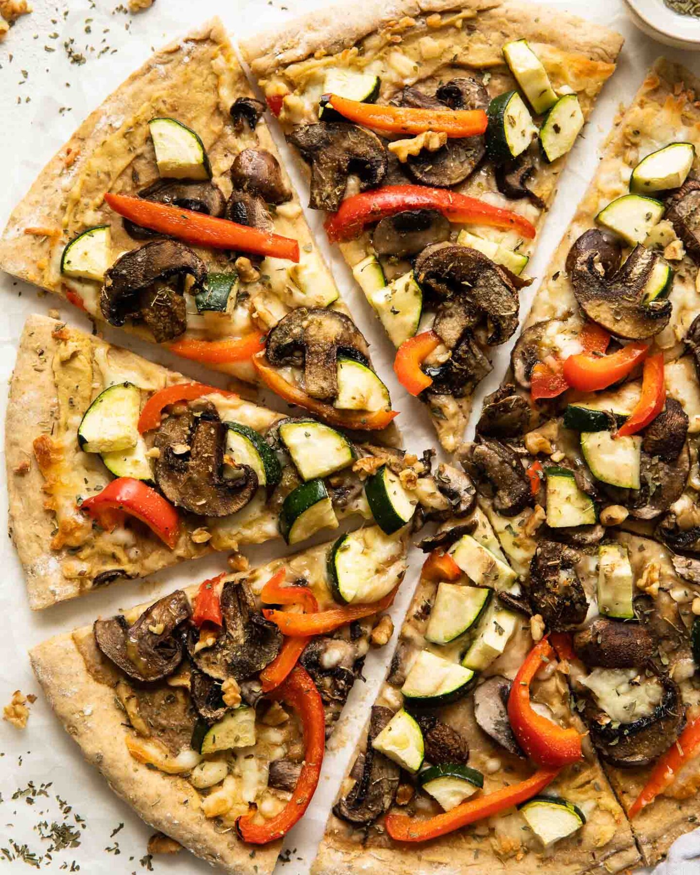 Vegan Hummus pizza with mushrooms, zucchini, and red peppers.