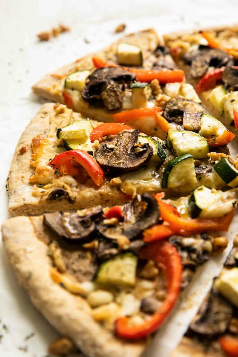 Angled shot of Vegan Red Pepper Hummus Pizza.