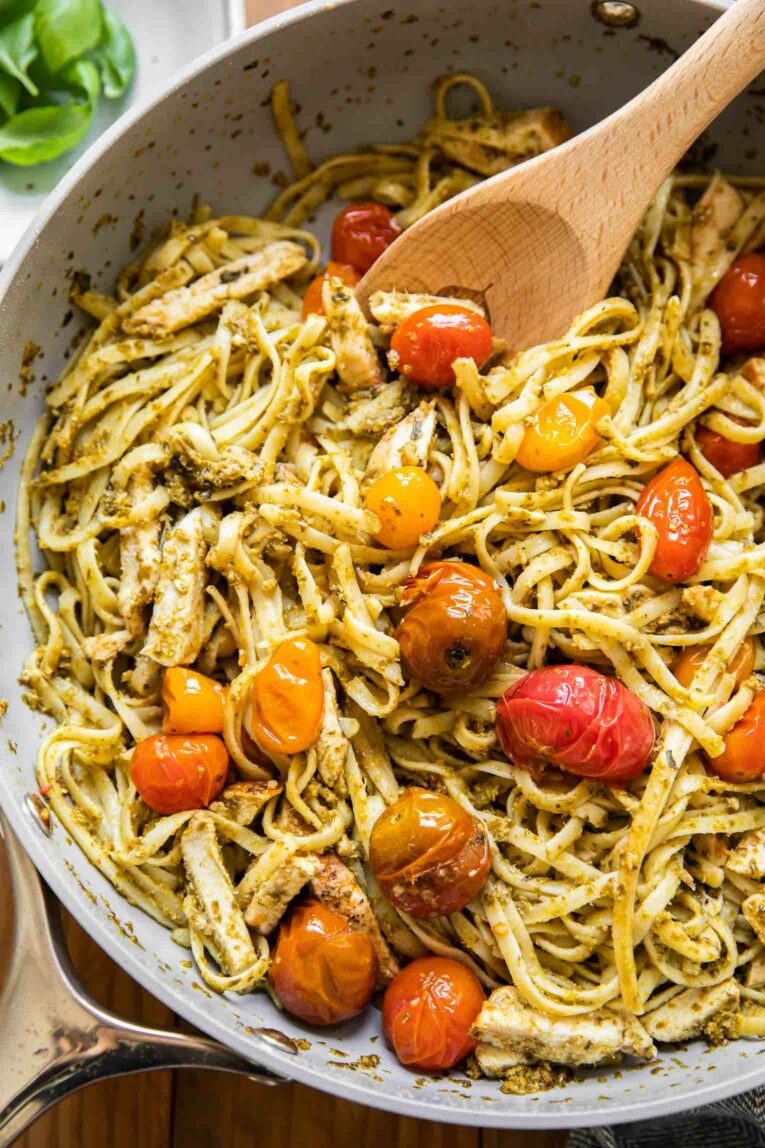 Pasta with pesto and tomatoes in a pan.