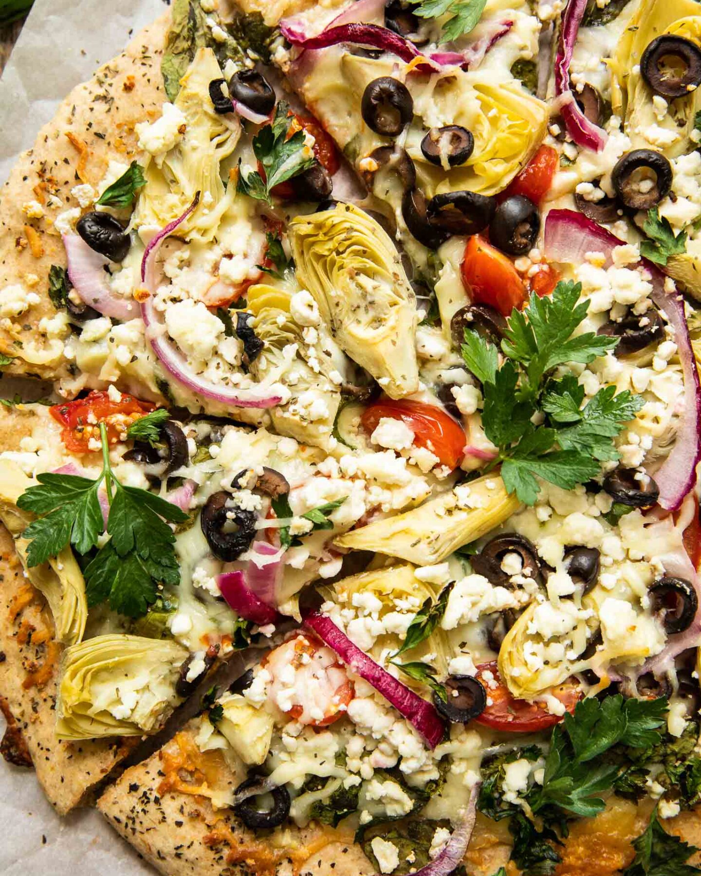 Top shot of easy mediterranean pizza with artichokes, parsley, and feta cheese.
