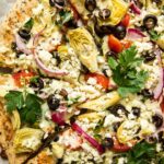 Top shot of easy mediterranean pizza with artichokes, parsley, and feta cheese.