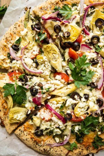 Top shot of easy mediterranean pizza with artichokes, parsley, and feta cheese.