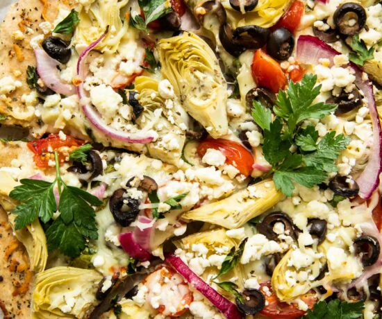 Top shot of easy mediterranean pizza with artichokes, parsley, and feta cheese.