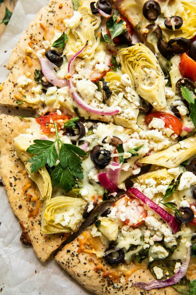 Close up of Mediterranean pizza slices.