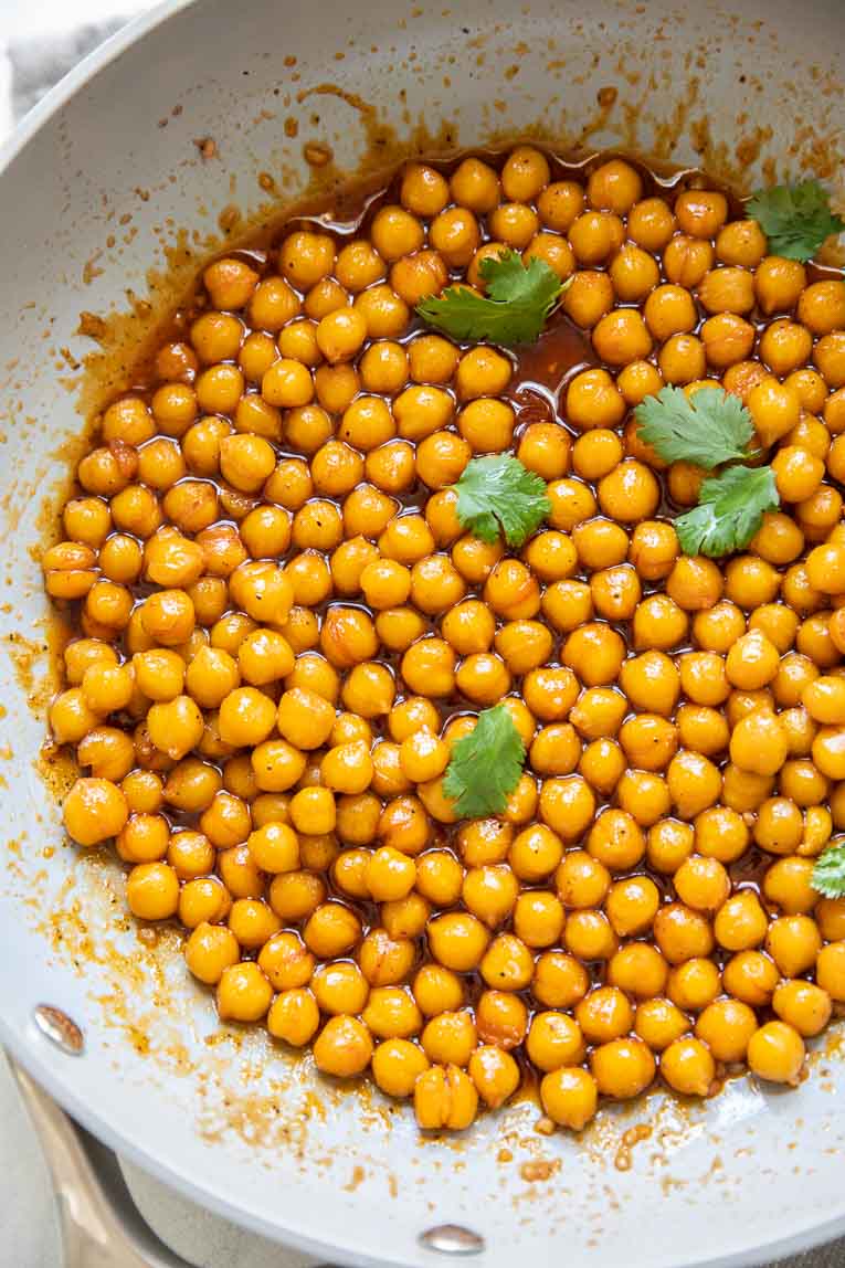 Hot honey chickpeas being cooked in a skillet.