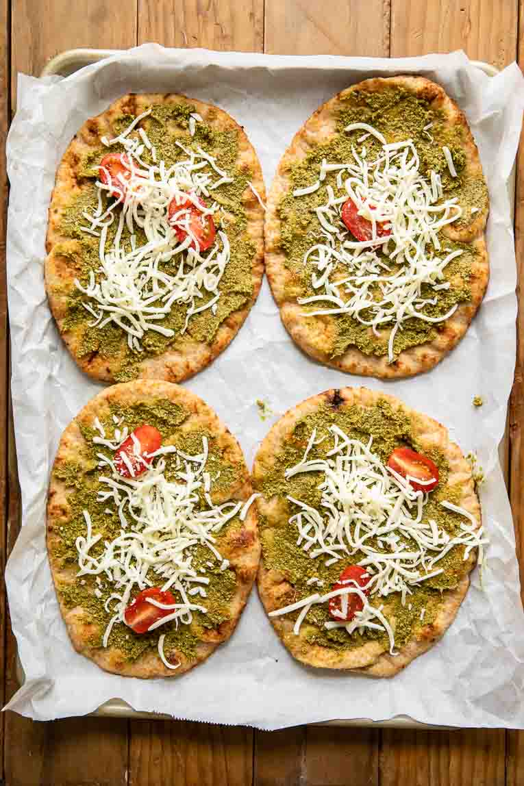 Spinach pesto, mozzarella, and tomatoes on naan bread.