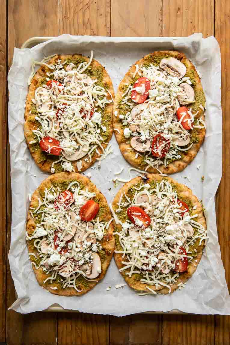 Spinach Pesto, goat cheese, and mushrooms on naan bread pizzas.