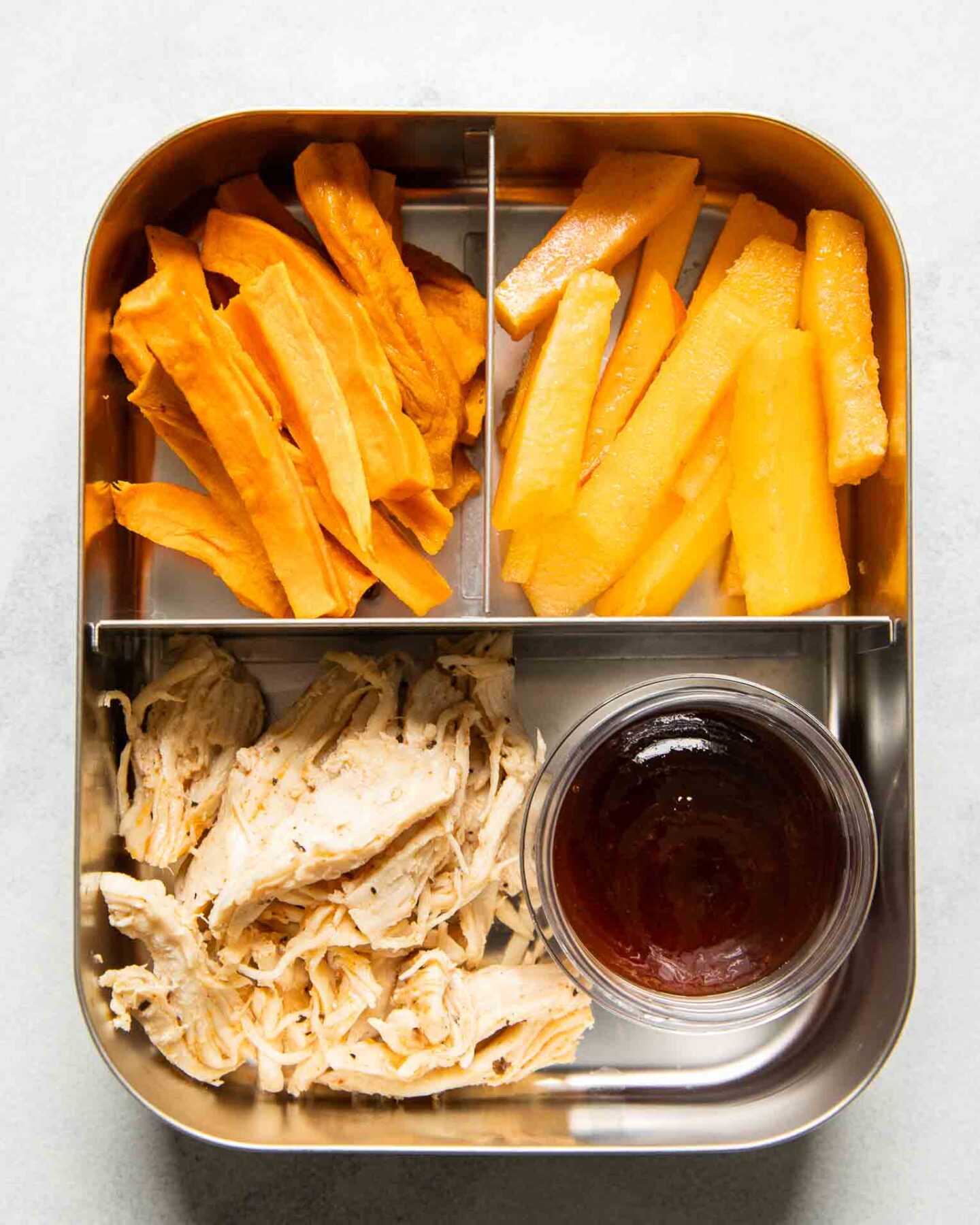 Shredded chicken with barbecue sauce, sweet potato fries, and peaches.
