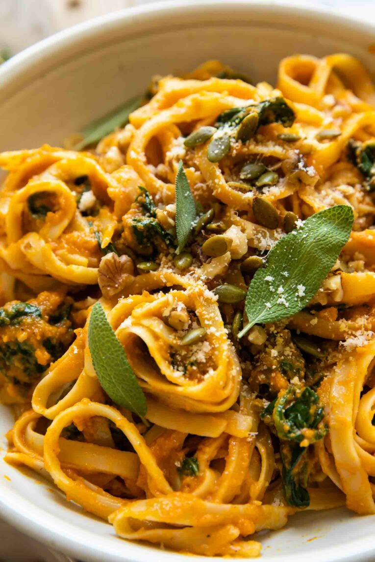 Angled shot of pumpkin pasta recipe with sage and spinach.