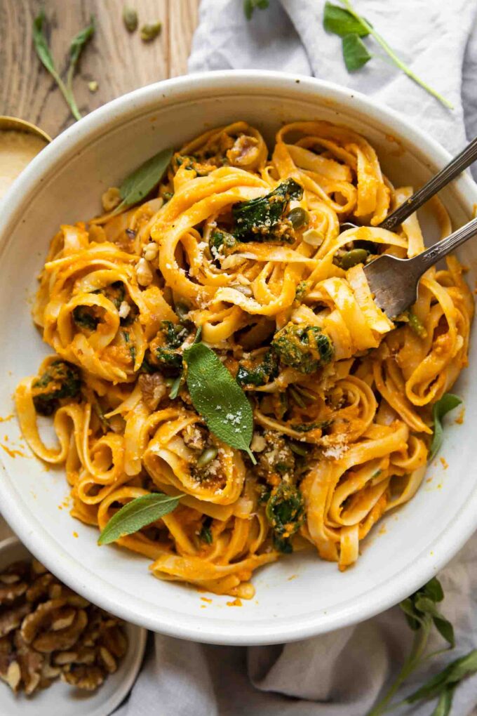 Creamy Pumpkin Pasta in a white bowl with forks.