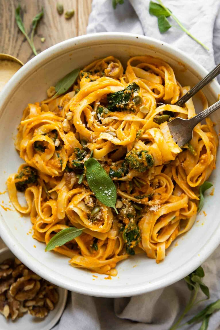 Creamy Pumpkin Pasta in a white bowl with forks.