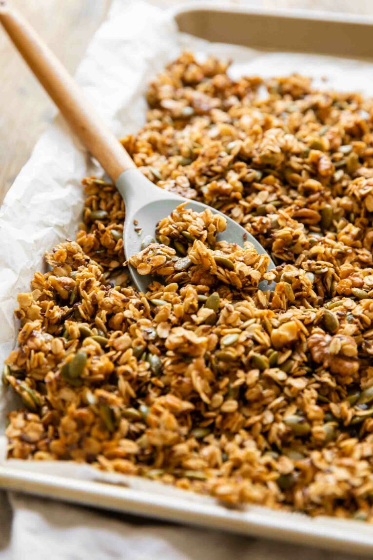 Angled shot of Pumpkin Flax Granola recipe on a baking pan.