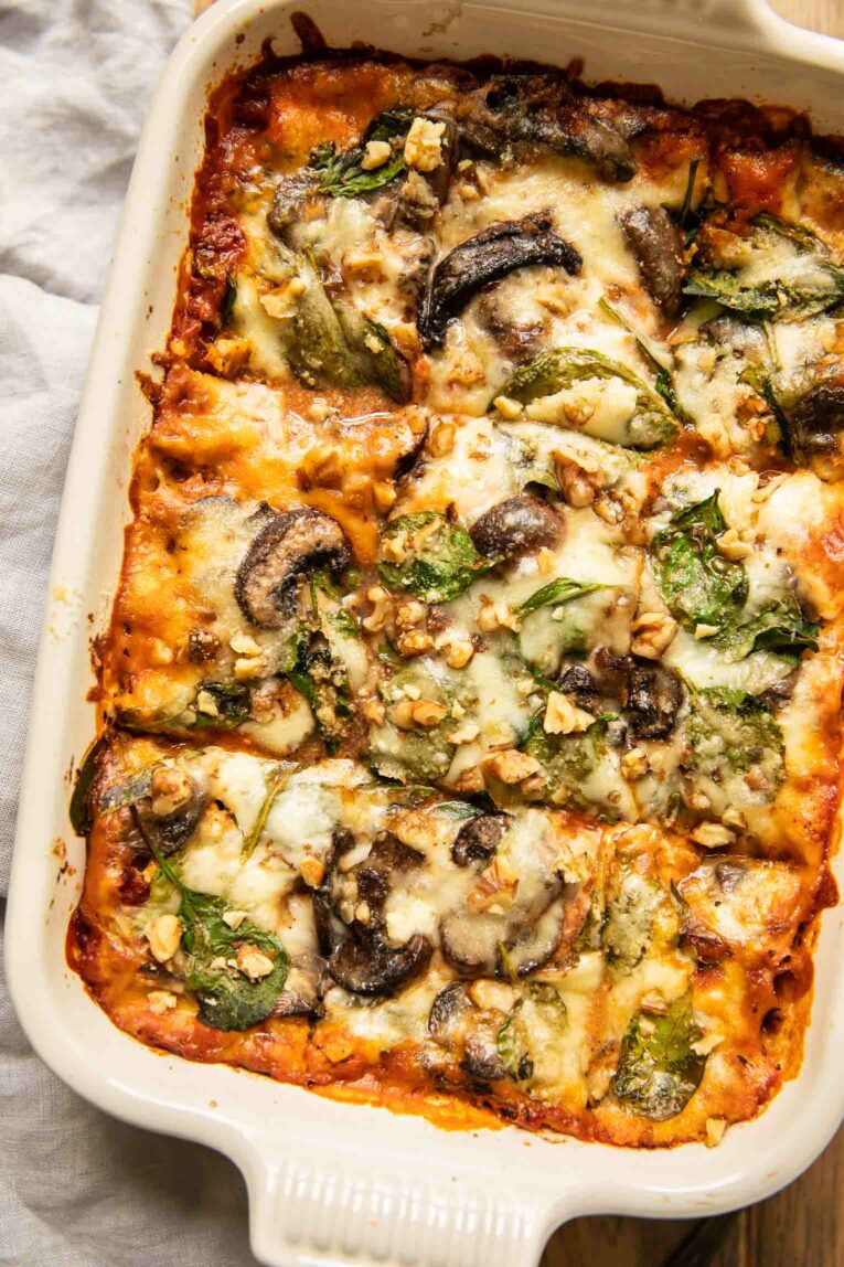 Top shot of sliced vegetarian lasagna in a white casserole dish.