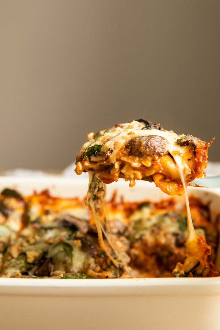 Across shot of vegetarian lasagna being removed from pan with spatula.